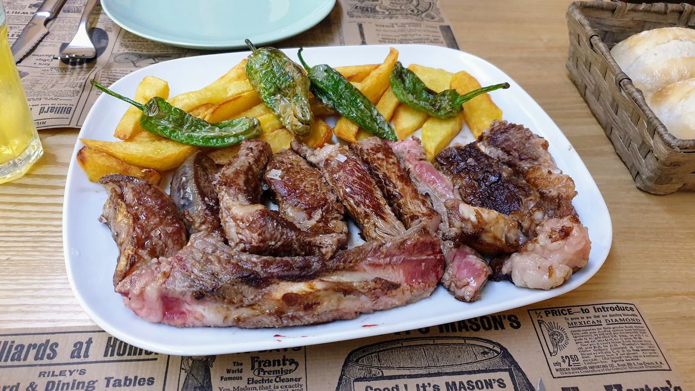 Chuletón a la parrilla con patatas fritas y pimientos de Padrón